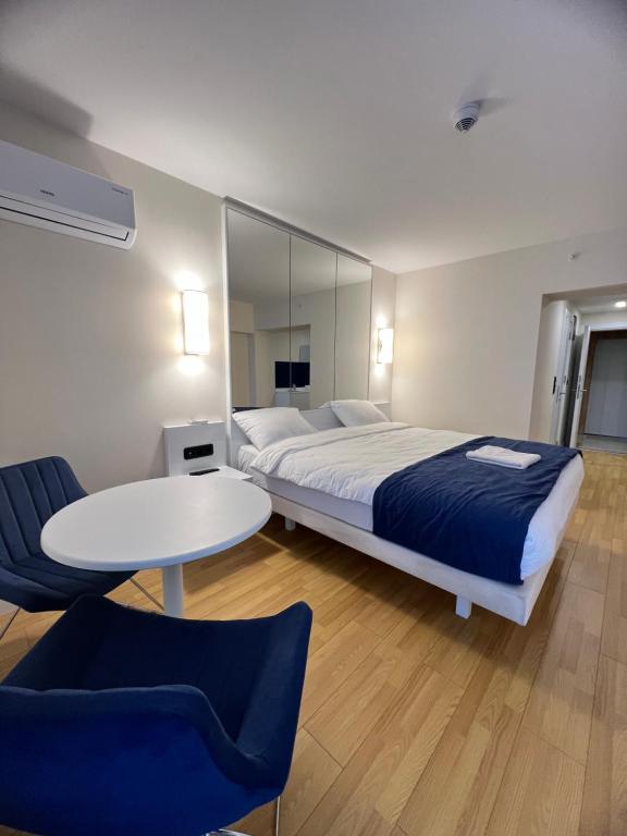 巴统Orbi City Batumi的一间卧室配有一张大床和一张桌子及椅子