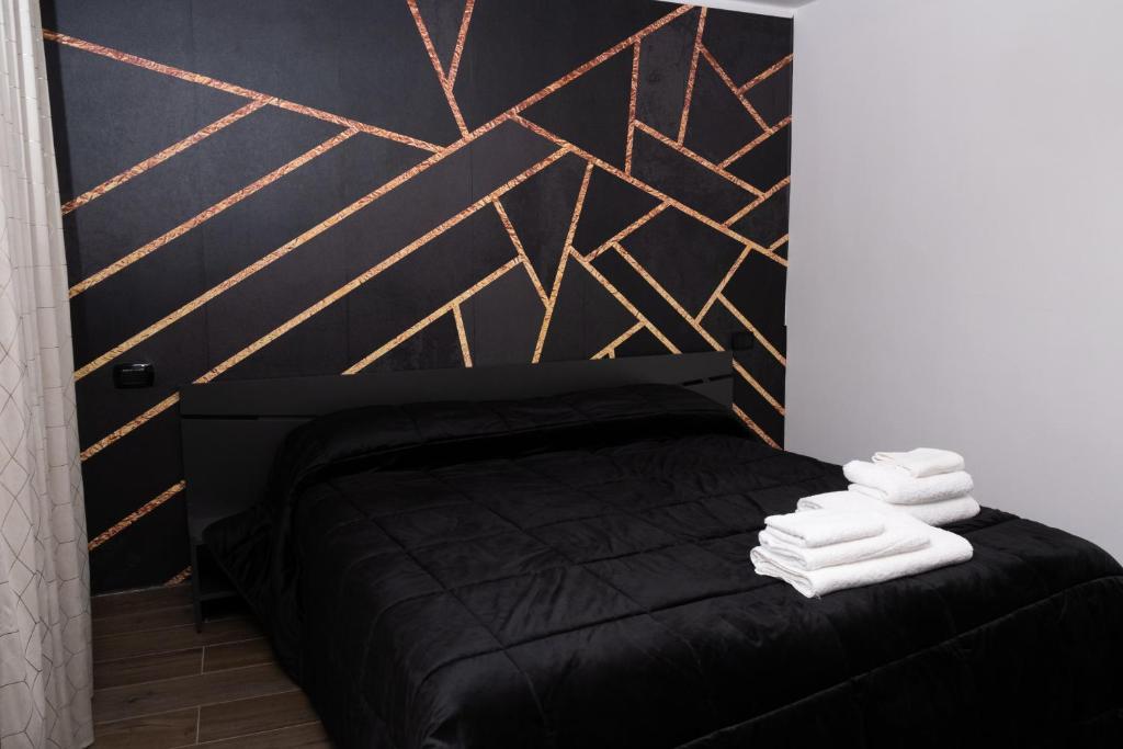 那不勒斯Napoli Center Suite Palmentieri的一间卧室配有黑色床和白色毛巾