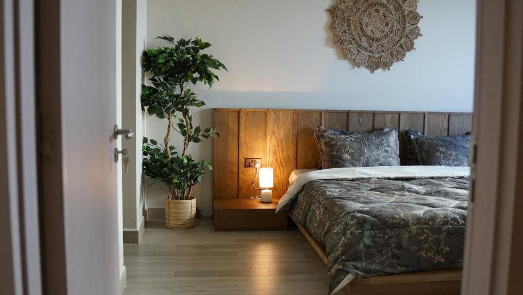 阿布扎比2 bedroom apartment Wabi Sabi in Yas的一间卧室配有床、植物和灯
