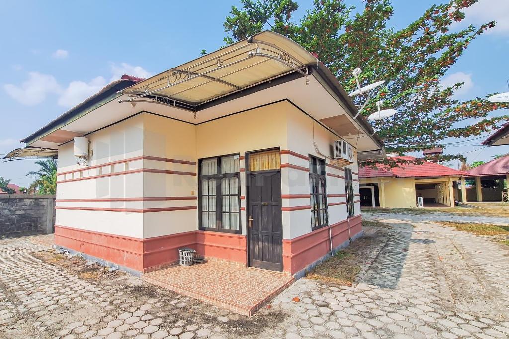 帕朗卡拉亚Aman Guest House Redpartner的一个小房子,设有大窗户