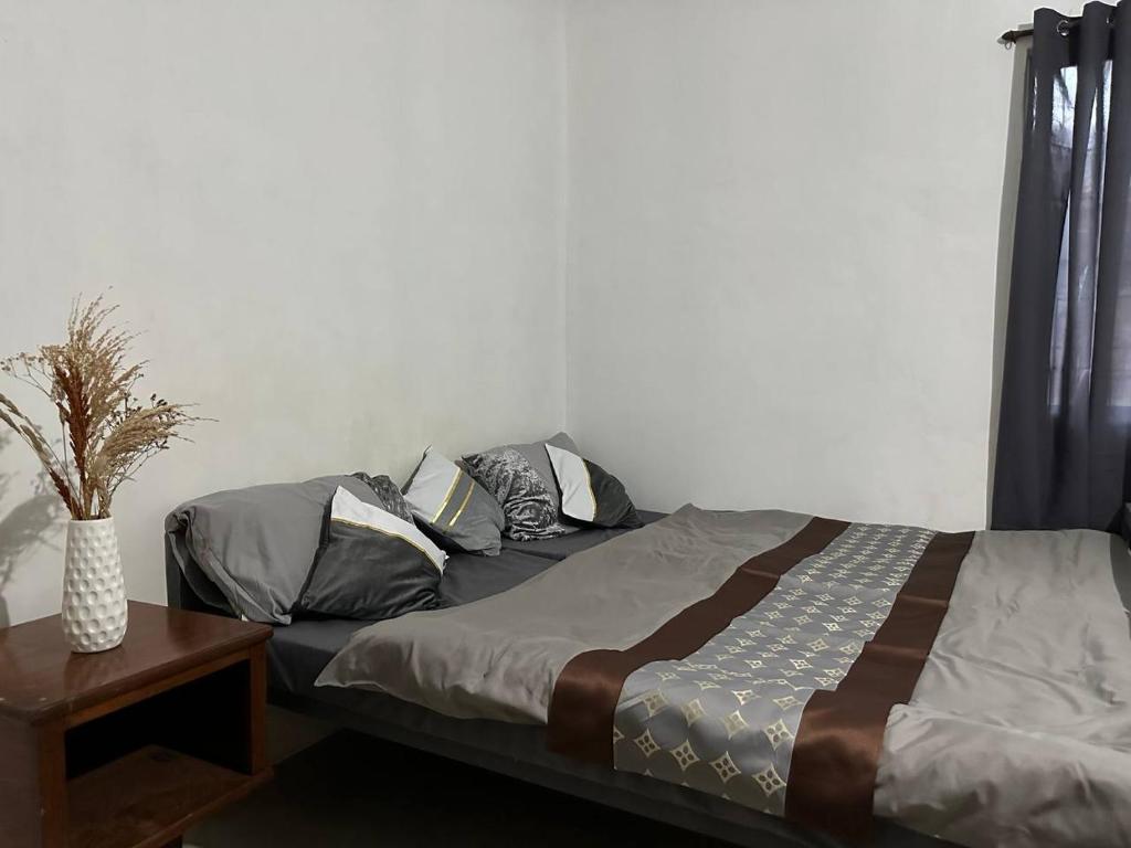 科隆House in Coron-The Grey House的一间卧室配有一张带枕头和桌子的床
