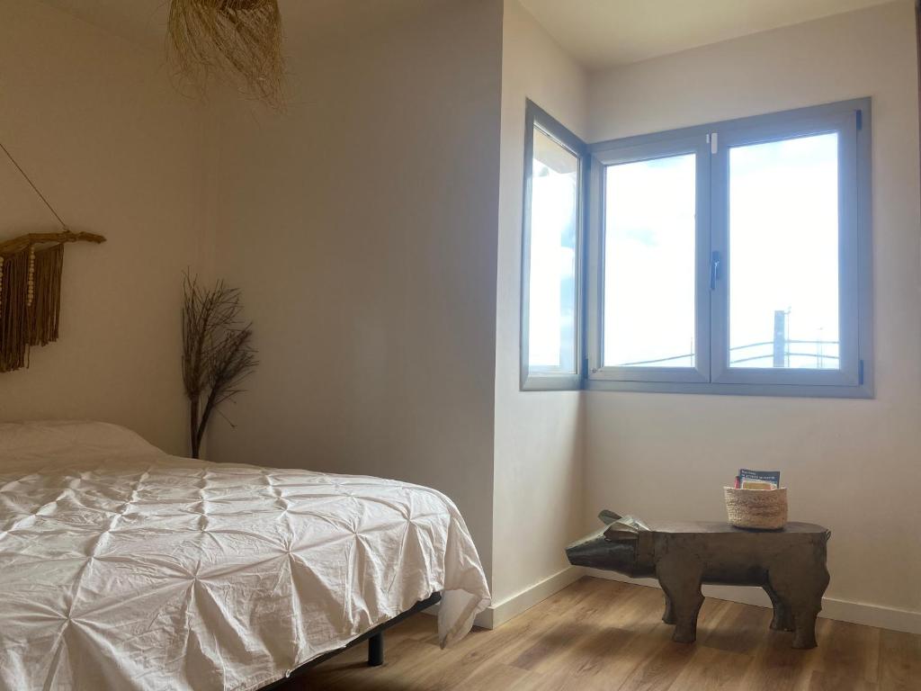 科蒂略Casa Tela Marinera的一间卧室配有一张床、一张桌子和一个窗户。