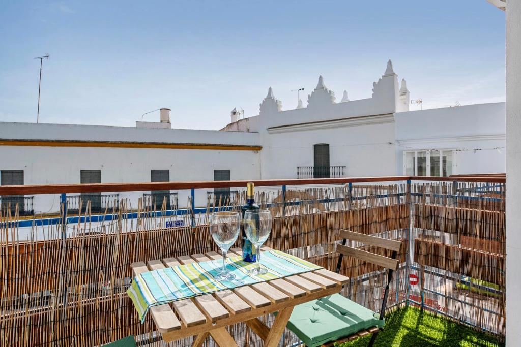 科尼尔-德拉弗龙特拉Apartamento Suite Arco Solo Parejas的阳台上的桌子和两杯酒杯