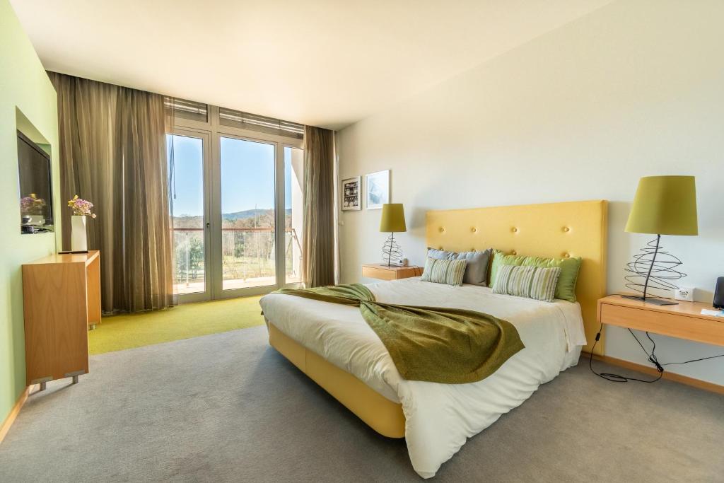 奥莱罗斯圣玛格丽达酒店 的一间卧室设有一张大床和一个大窗户