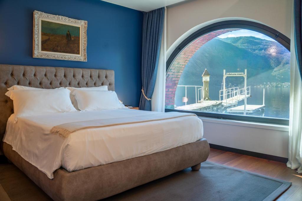 曼德洛德拉廖曼德洛别墅拉里奥度假村 的一间卧室设有一张大床和拱形窗户