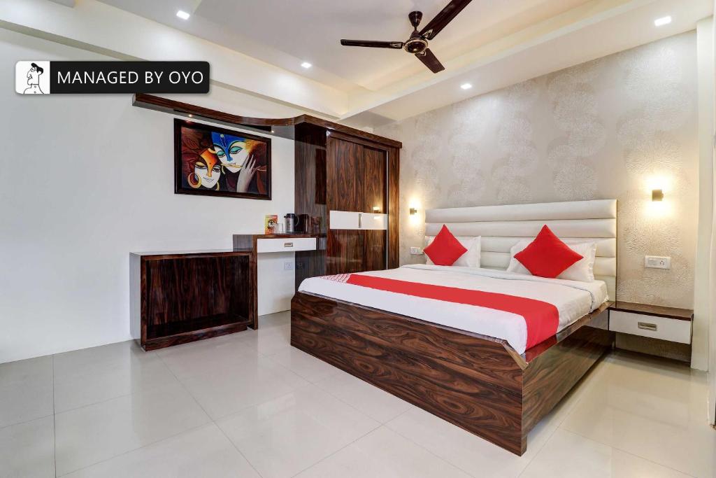 勒克瑙Super OYO Natraj Inn Near SGPGI - Managed by Company的一间卧室配有一张带红色枕头的大床