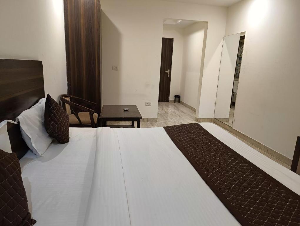 新德里Hotel Samara Kingdom Near Delhi Airport的一间卧室配有一张大床和一张桌子