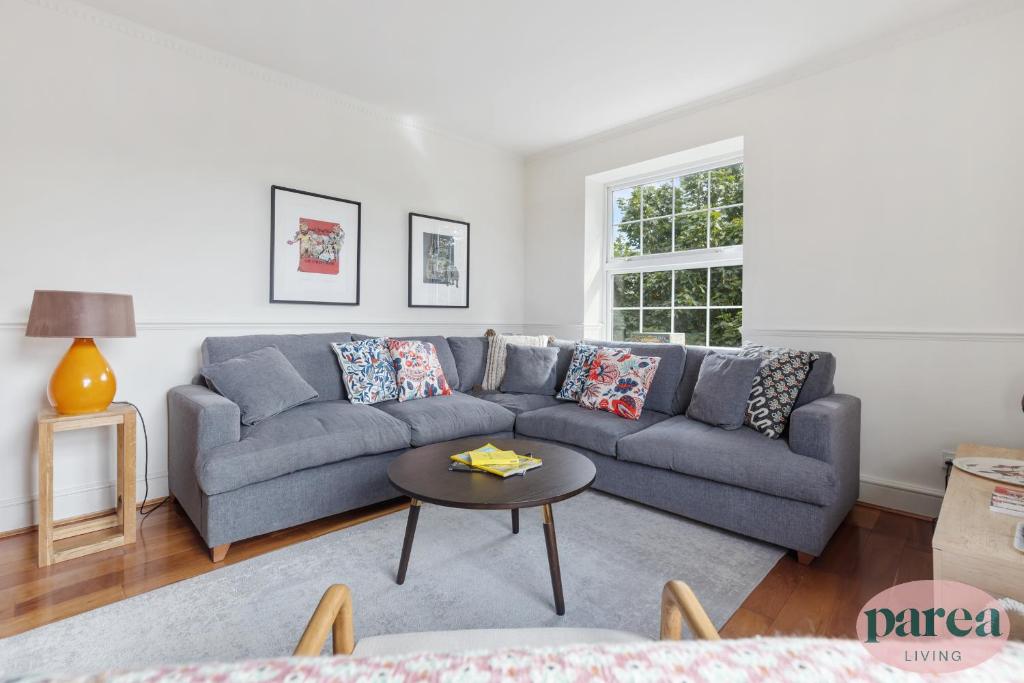 伦敦Parea Living - Stylish Islington 1-Bed Flat, 6min Walk to Tube的客厅配有蓝色的沙发和桌子