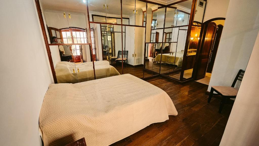 萨尔塔Valhalla Hostel & Suites的卧室配有白色的床和镜子