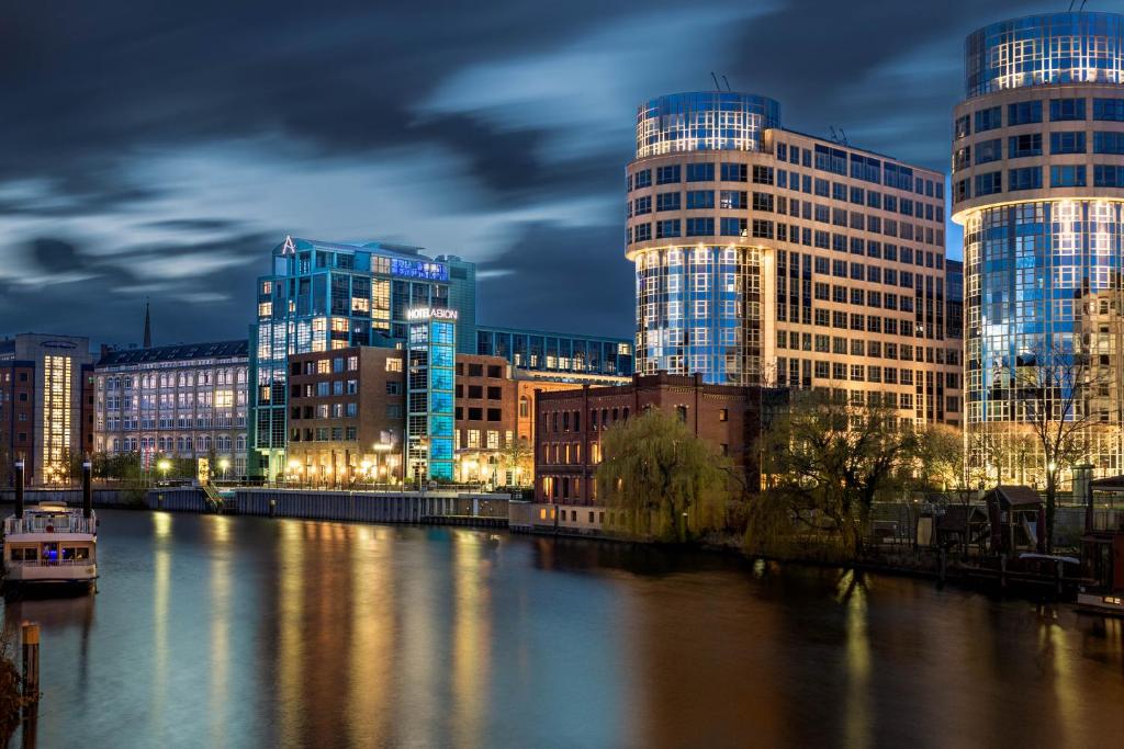 柏林柏林亚美隆亚里安斯普林伯根酒店的一座有高楼和夜河的城市