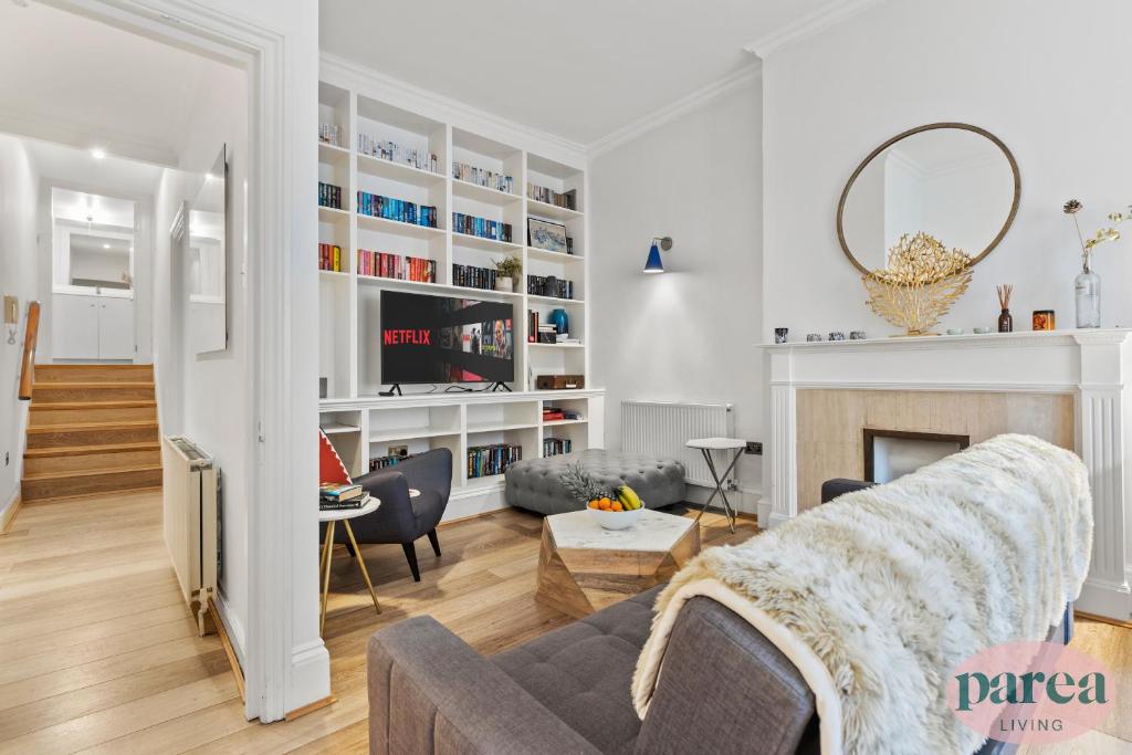 伦敦Parea Living - South Kensington, Elegant 1-Bedroom Flat, WFH Desk的带沙发和壁炉的客厅