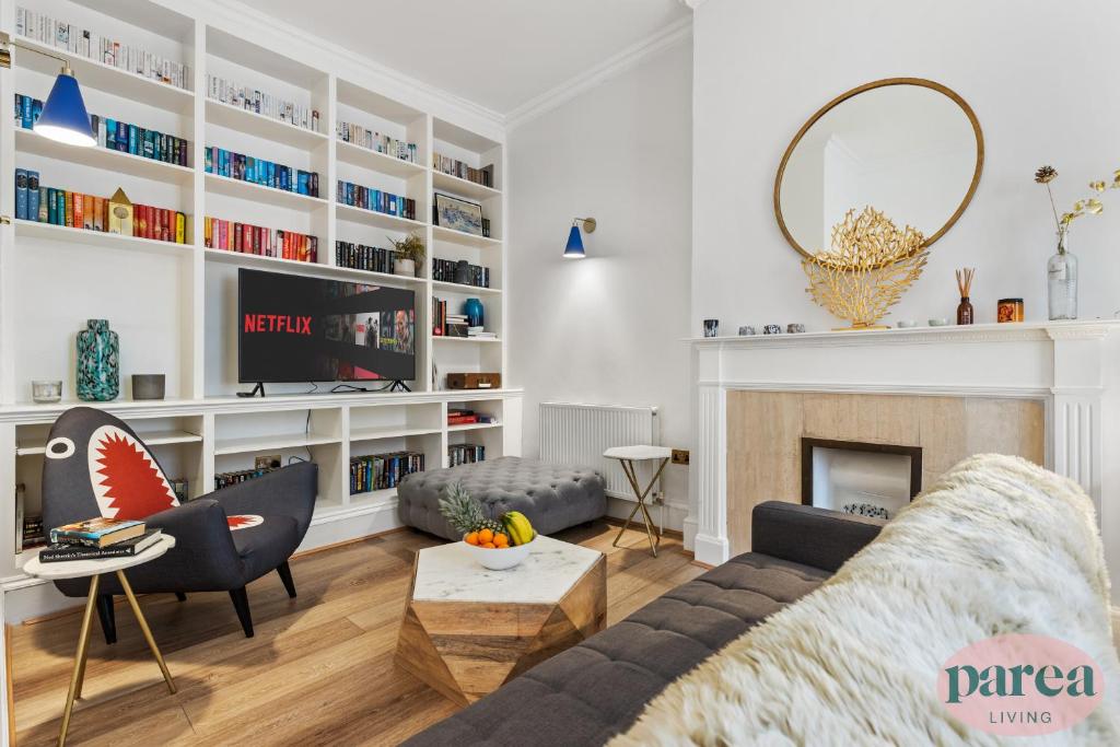 伦敦Parea Living - South Kensington, Elegant 1-Bedroom Flat, WFH Desk的带沙发和壁炉的客厅