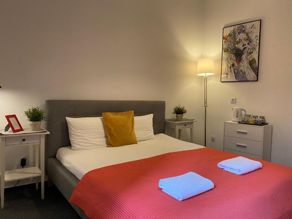 克拉科夫Millenium Apartments的一间卧室配有一张床,上面有两条毛巾