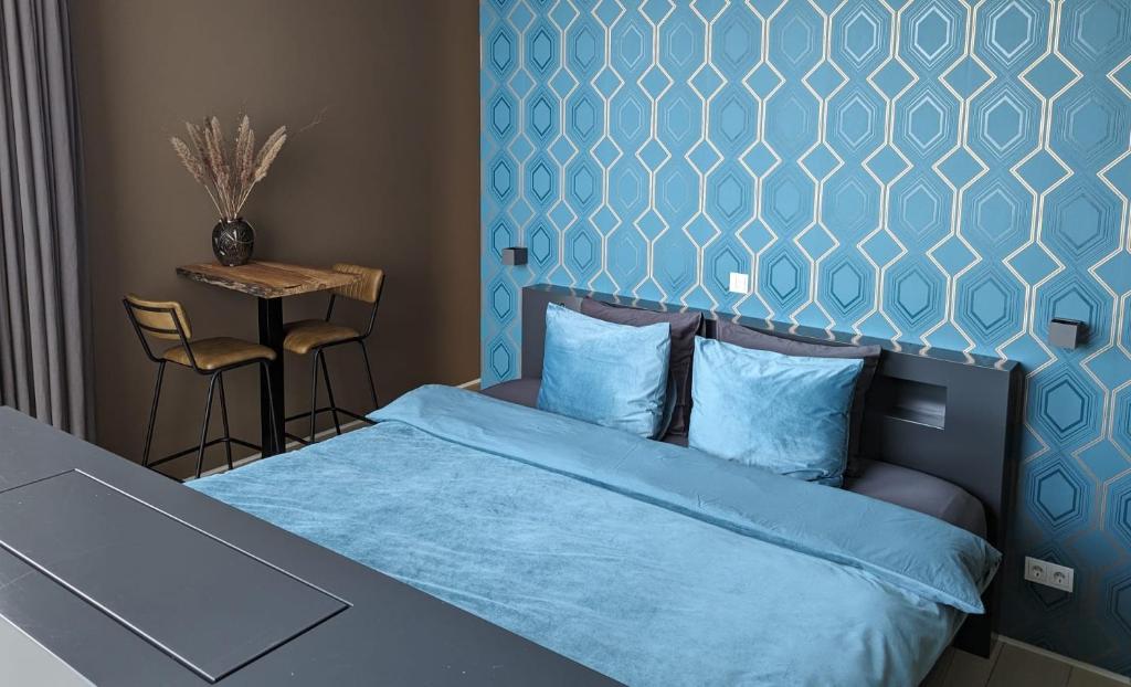博克斯特尔Bed & Wellness Boxtel, luxe kamer met airco en eigen badkamer, ligbad的一间卧室配有一张蓝色墙壁的床