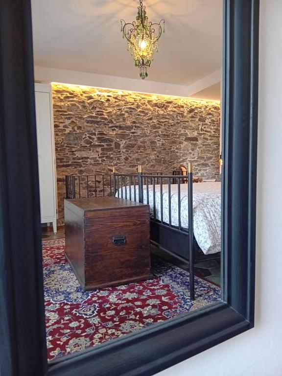奥尔塔圣朱利奥Casa Longhi的镜子反射着一间卧室,卧室配有一张床和木制的箱子