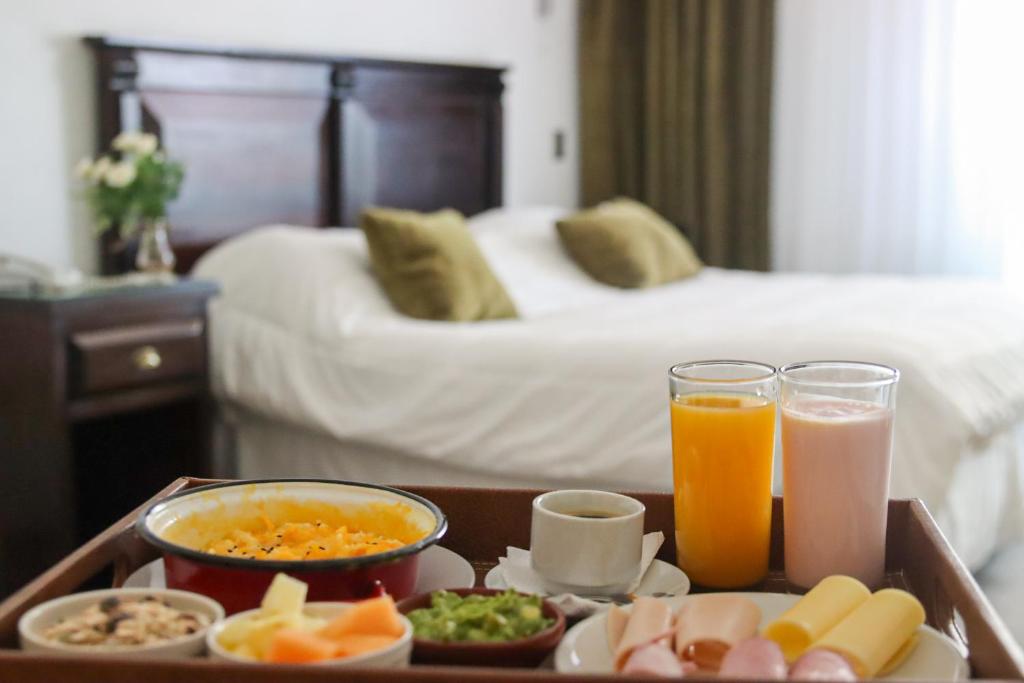 康塞普西翁Hotel Terrano Concepción的在酒店房间桌上放着一盘食物和饮料