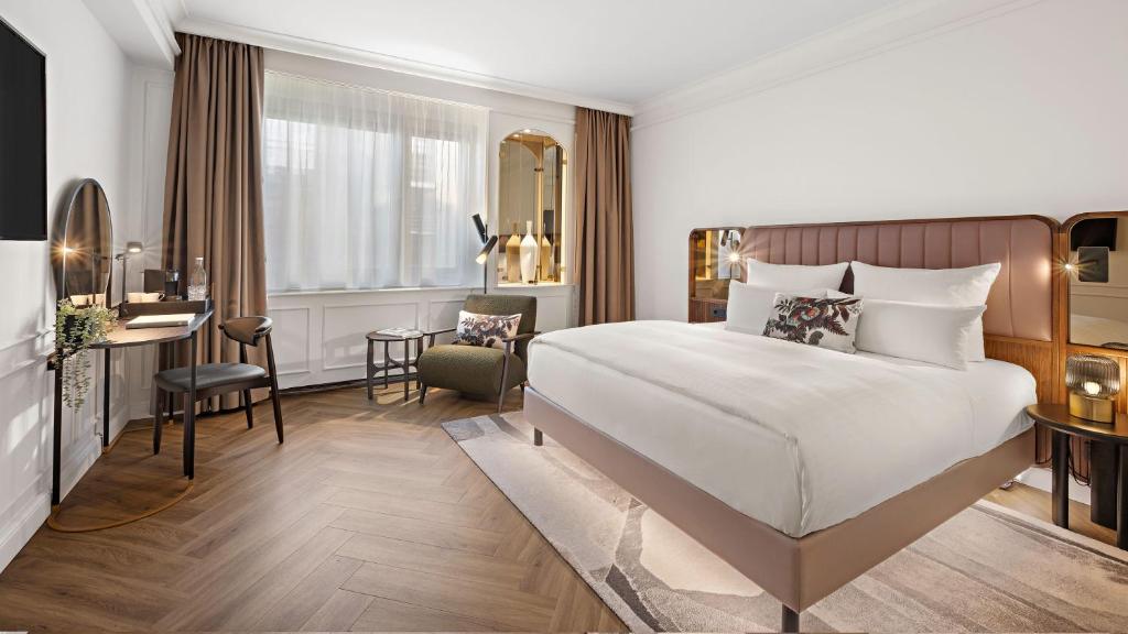 柏林柏林布里斯托尔酒店的酒店客房设有一张大床和一张书桌。