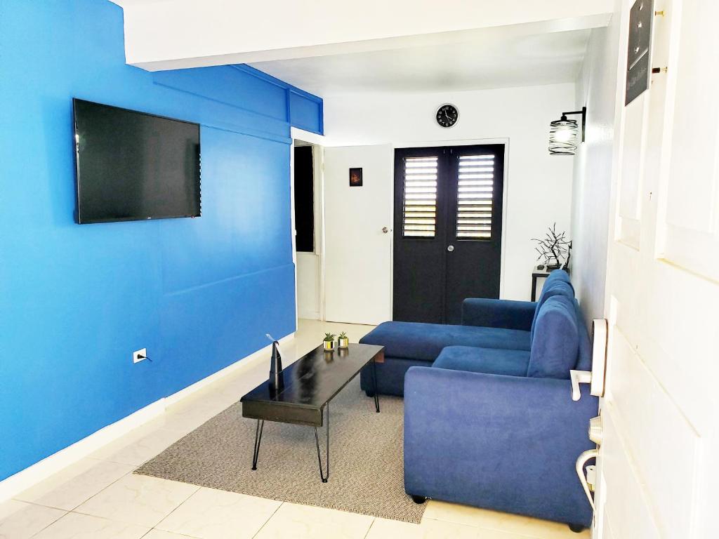 蒙特哥贝the Blue Ackee的客厅拥有蓝色的墙壁和蓝色的沙发