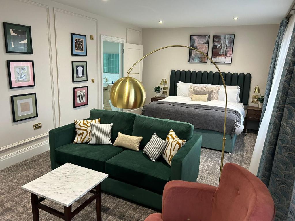 谢伯恩The Hillbrook Hotel & Spa - Sherborne的客厅配有绿色沙发和床。