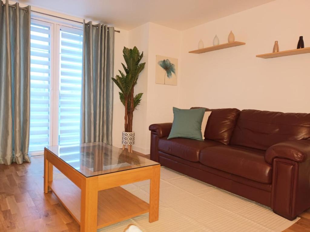 阿伯丁Spacious Elegant 2-BR Apartment in Aberdeen City Centre的客厅配有棕色沙发和桌子
