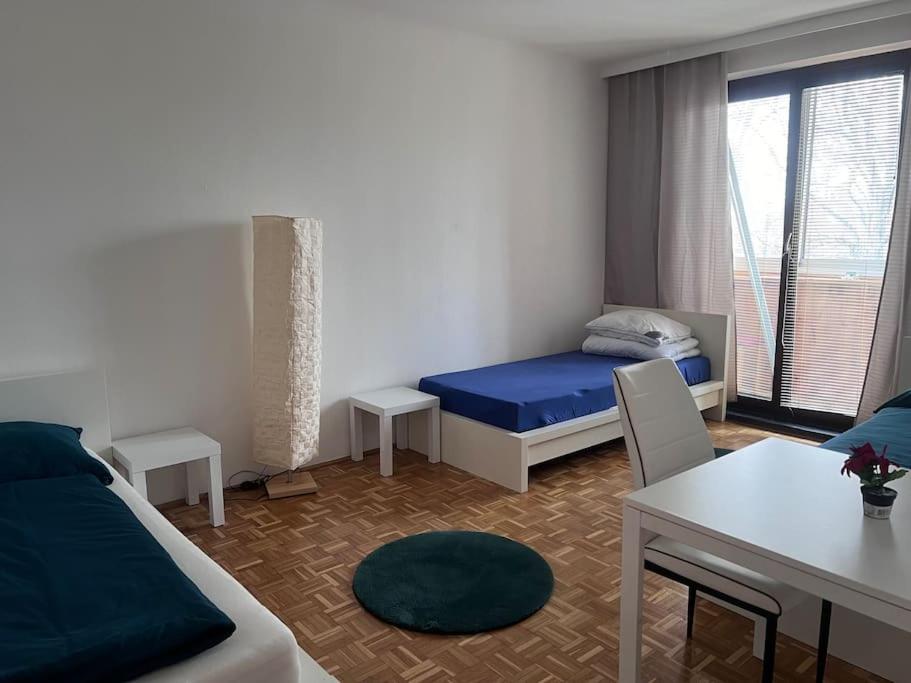 施韦夏特Ruhige Wohnung in Schwechat nähe Flughafen的一间卧室配有一张床、一张桌子和一张桌子