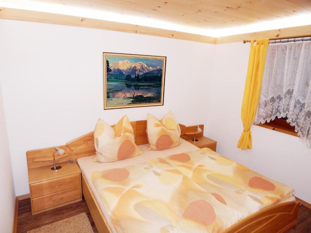 拉姆绍Chalet Ramsau的卧室配有一张床,墙上挂有绘画作品