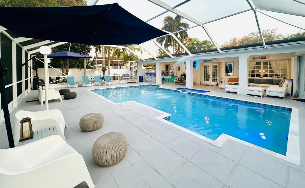迈阿密Home in Miami的一个带遮阳伞和白色椅子的游泳池