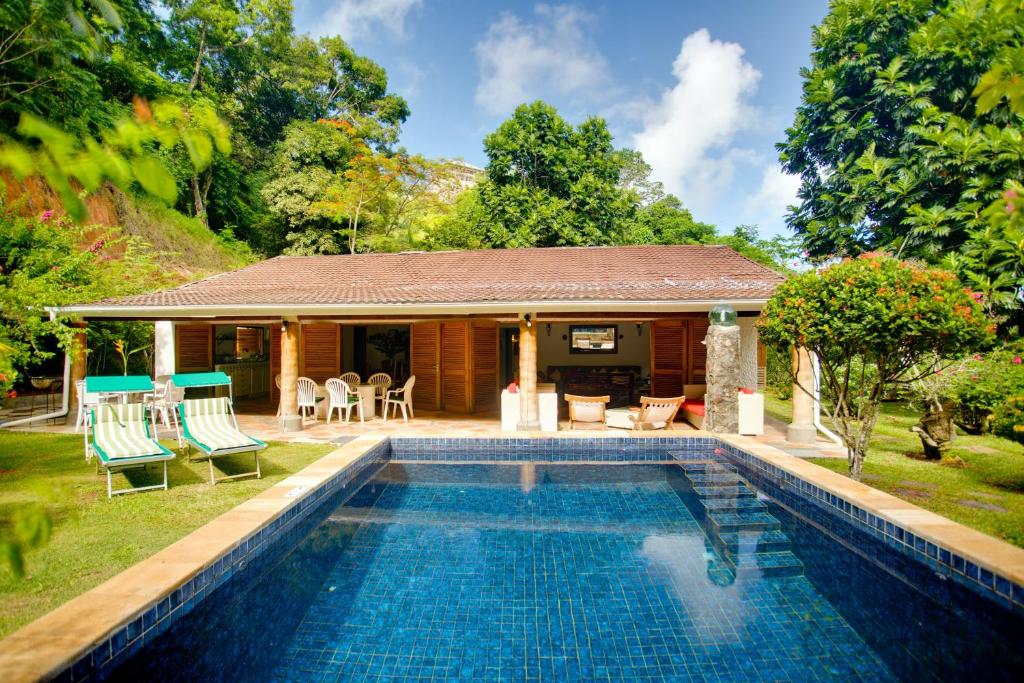 塔卡马卡Coté Sud - Unique Villa & Bungalows Intendance Road的房屋前有游泳池的房子