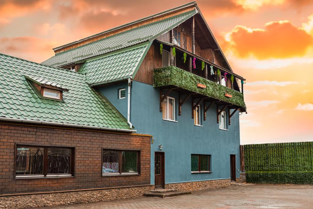 克卢日-纳波卡Casa Rosu的带阳台的绿色屋顶房屋