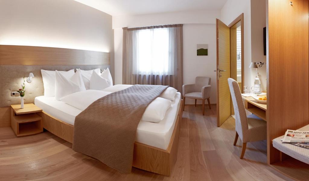 博尔扎诺波斯特葛蕾司酒店的酒店客房设有一张大床和一张书桌。