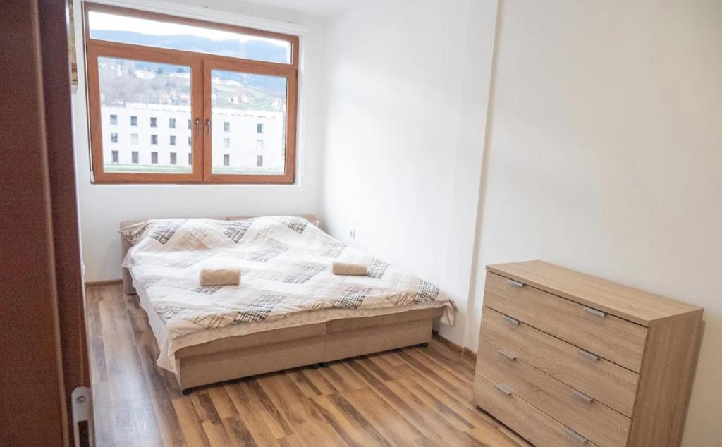 维舍格勒Apartmani Bašta的一间卧室配有床、窗户和梳妆台