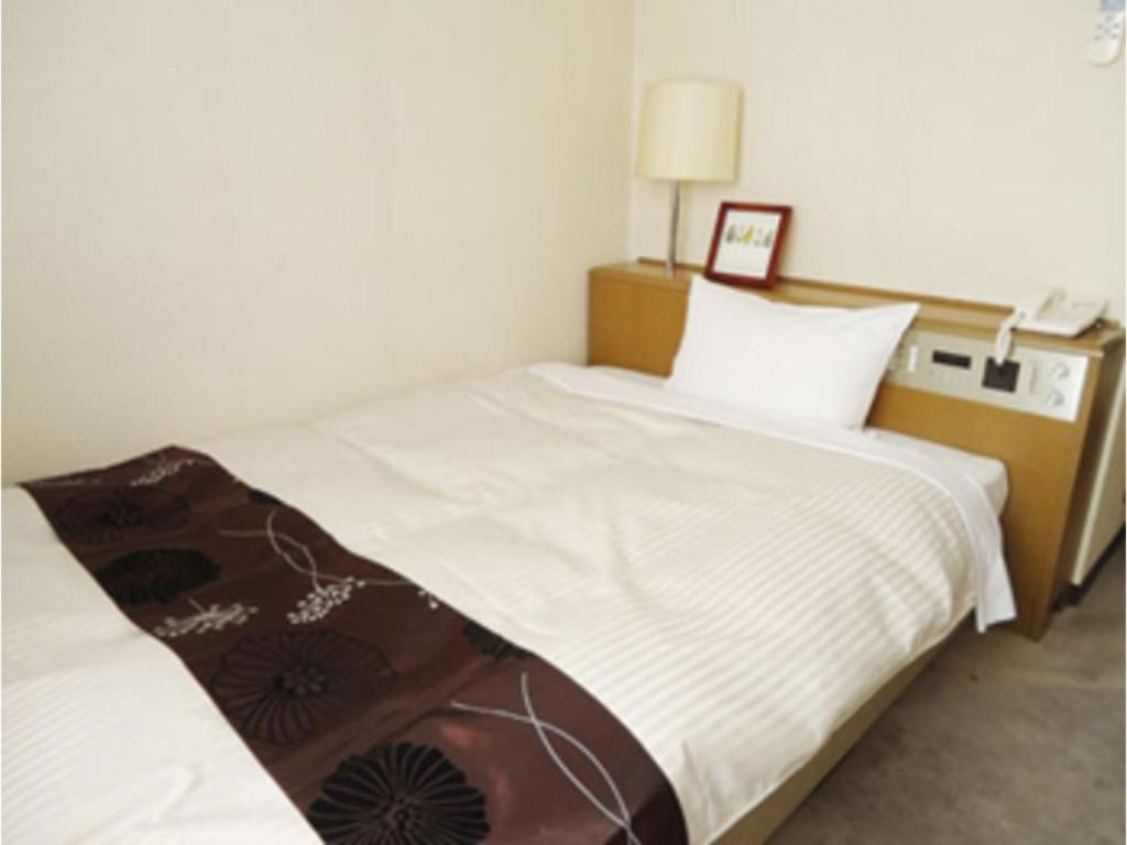 仓吉市Hotel Tohaku INN - Vacation STAY 01156v的一间卧室设有两张床,墙上配有一部电话