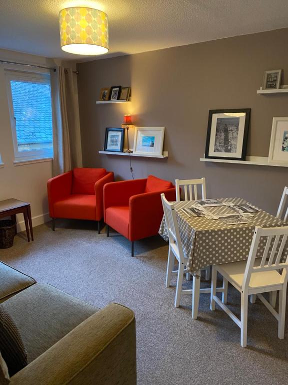 珀斯Stylish Loft Apartment in central Perth的客厅配有红色椅子和桌子