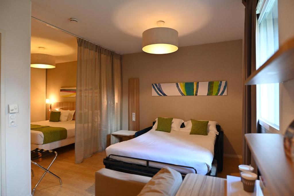 里昂Appart hôtel Q7 Lodge Lyon 7的酒店客房,设有两张床和一张沙发