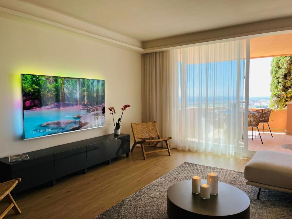 马贝拉Magna Lujoso apartamento en Marbella的一间带大电视的客厅和一间客厅