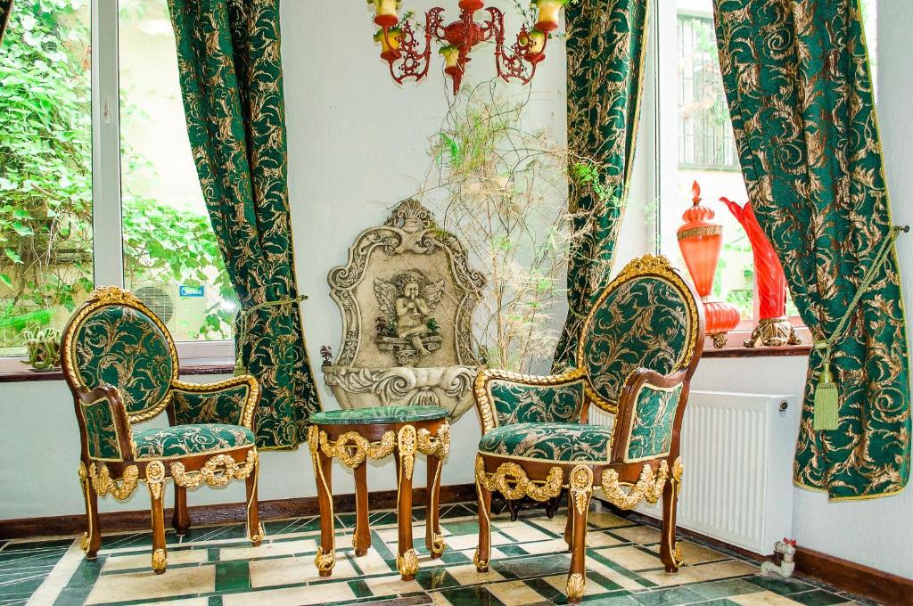 敖德萨德瑞谢里宾馆的一间设有三把椅子和镜子的房间