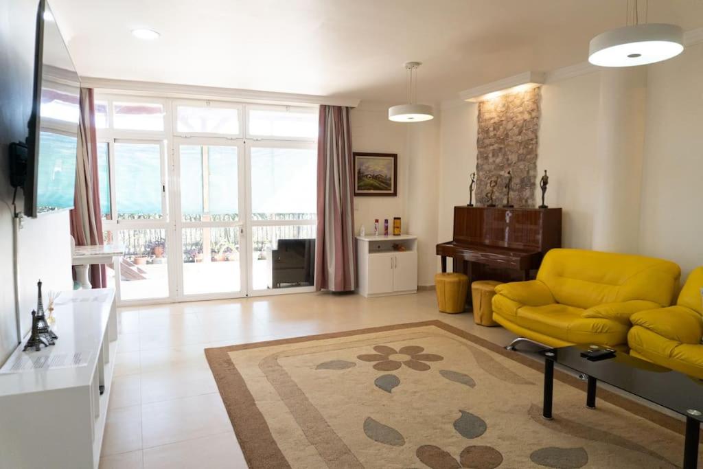 卡斯特利翁-德拉普拉纳Casa Moderna cerca de la PLAYA的客厅配有黄色的沙发和桌子
