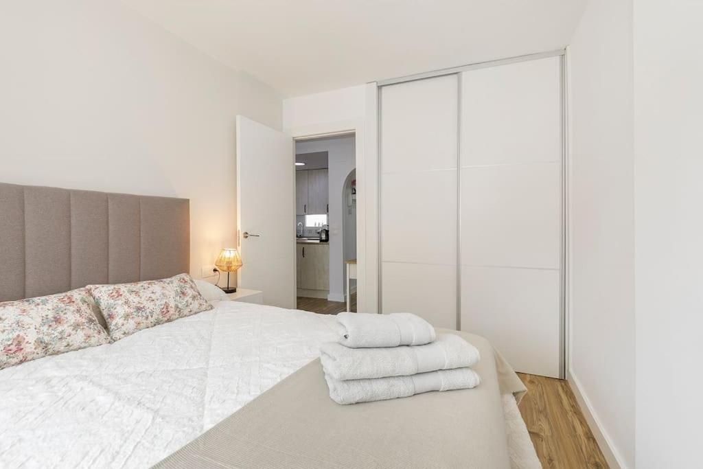 莫纳奇尔Apartamento Carmela的白色卧室,配有带毛巾的床