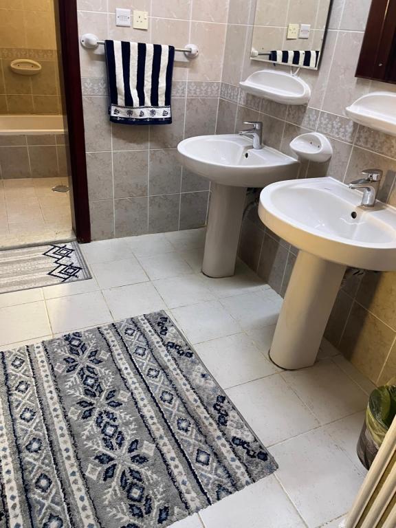 麦地那شقة فندقية的浴室设有2个水槽和地毯。