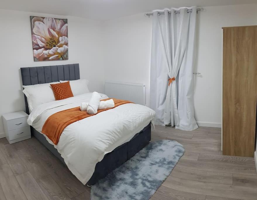 吉林汉姆Holiday Let - Entire modern home in Medway的一间卧室配有一张带橙色和白色枕头的大床