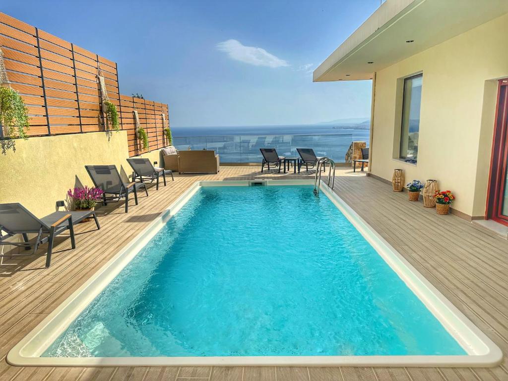 RodhiáVilla Balcony, Cozy Villa with Amazing View的一个带椅子的甲板上的游泳池以及一座房子
