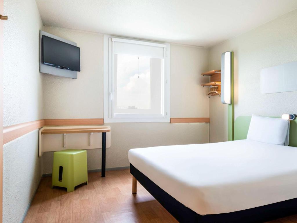 沙朗通勒蓬巴黎博泰赛宜必思快捷酒店的卧室配有白色的床和窗户。