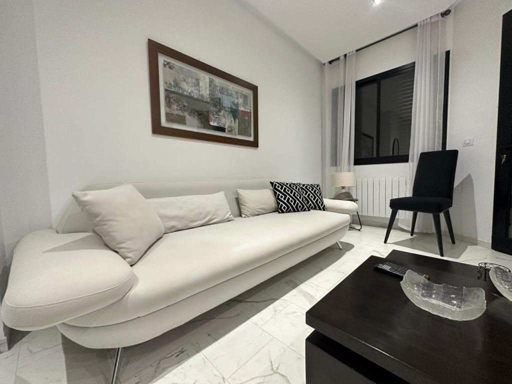 拉马萨Luxury appartement的客厅配有白色的沙发和桌子