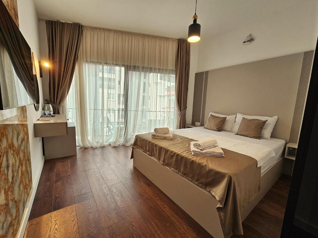 布德瓦Lolo Luxury rooms & suites的酒店客房设有一张床和一个大窗户