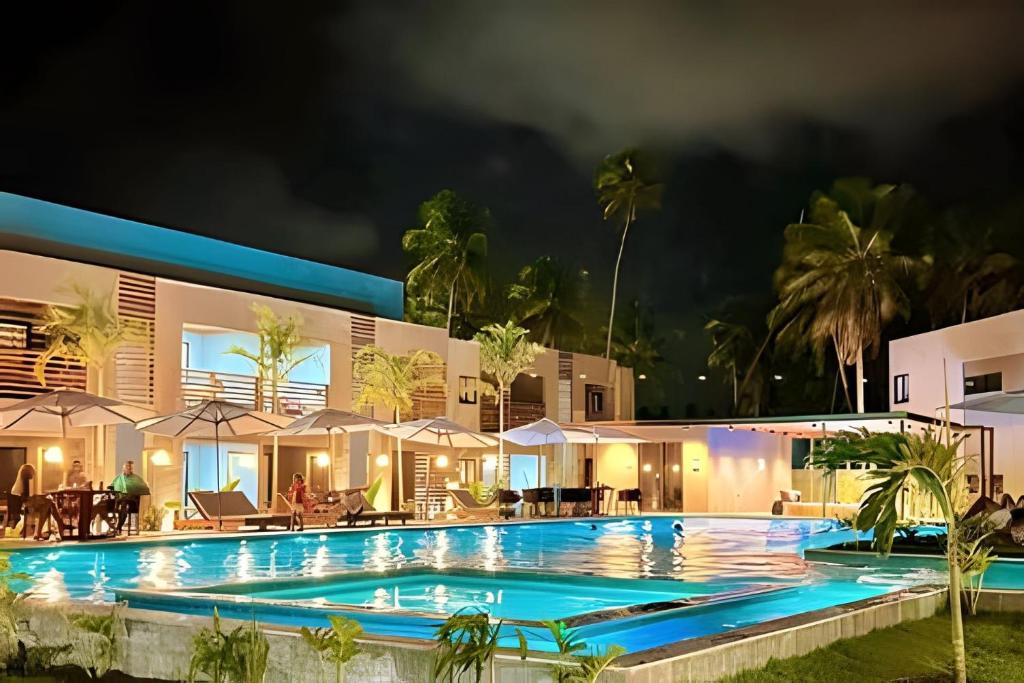佩德拉斯港Refúgio em Condomínio Resort na Rota dos Milagres的享有夜间度假村泳池的景致