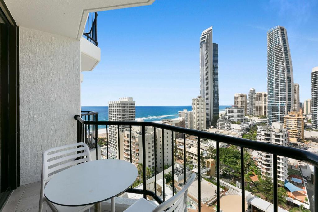 黄金海岸Sleek and Central Studio Apartment的阳台配有白色椅子,享有海景。