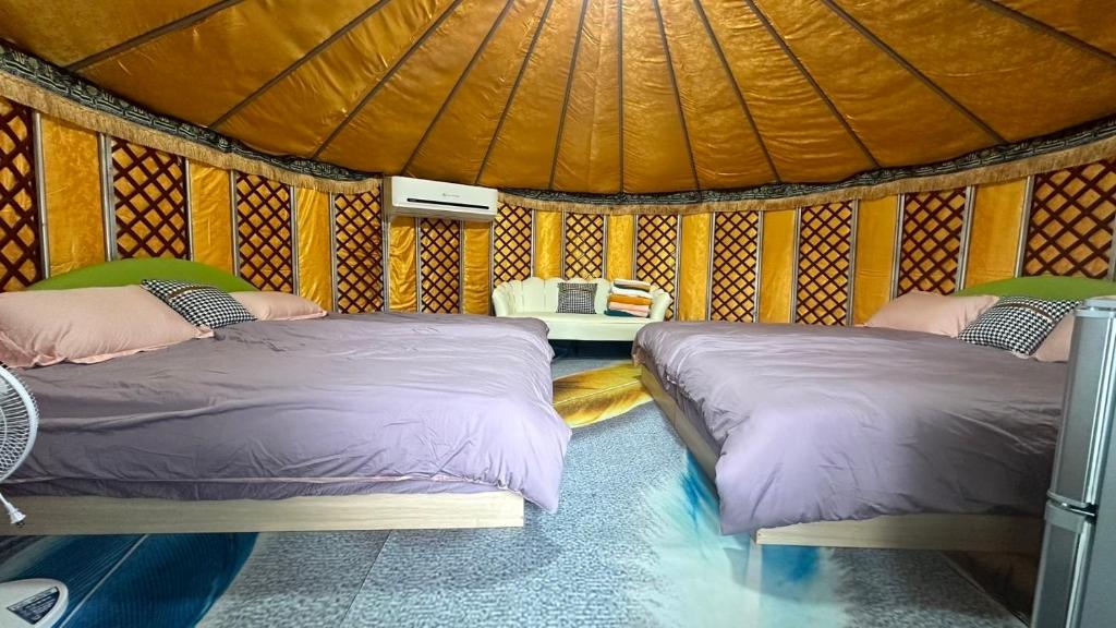 Lung-mu-ching落羽松民宿的蒙古包内一间卧室,配有两张床