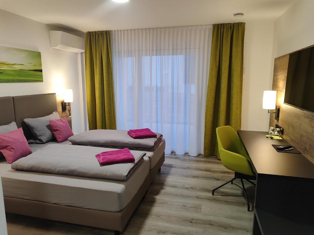 腓特烈港Hotel Stock Bäumle的酒店客房配有两张床和一张书桌