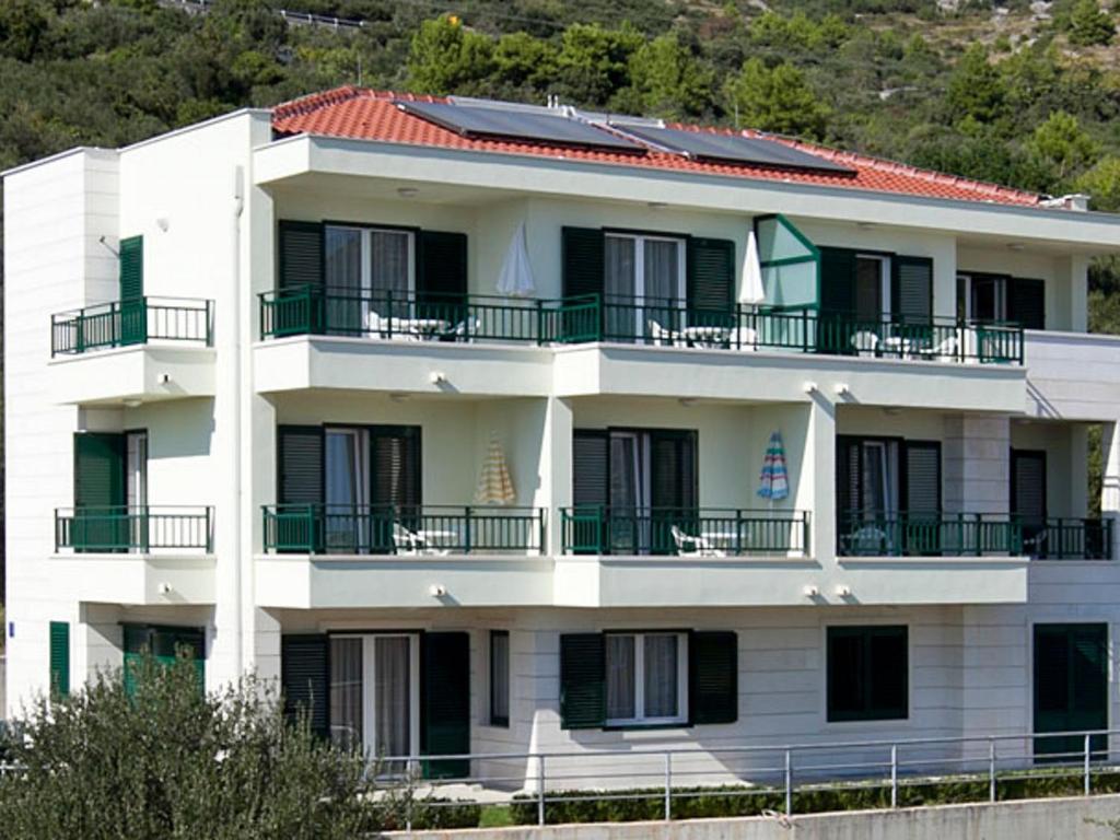 伊格拉恩Apartments by the sea Igrane, Makarska - 17292的一座白色的建筑,上面设有阳台