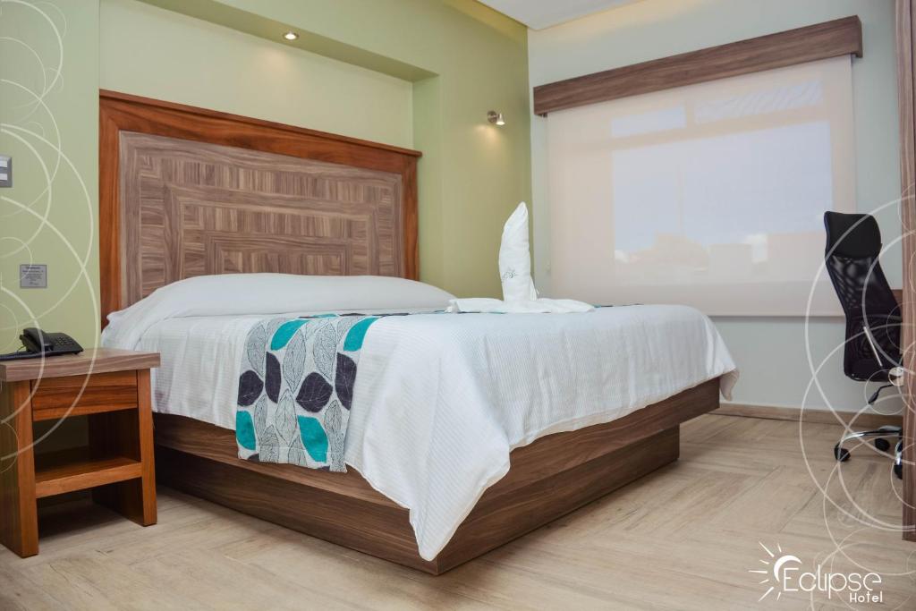 托卢卡HOTEL ECLIPSE TOLUCA的一间卧室配有一张床、一张书桌和一个窗户。